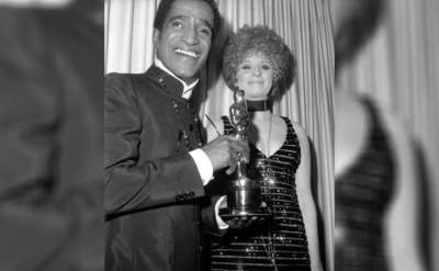 Sammy Davis Jr and Barbra Streisand at the Academy Awards holding an Oscar. 